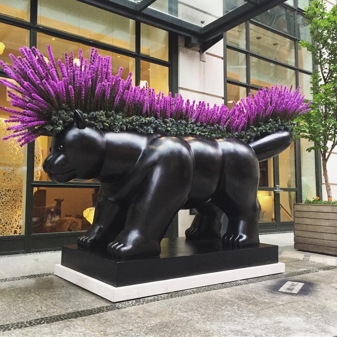 Black bear sculpture surrounded by purple Liatris flowers.